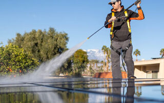 A Renovian cleaning solar panels on a roof.
