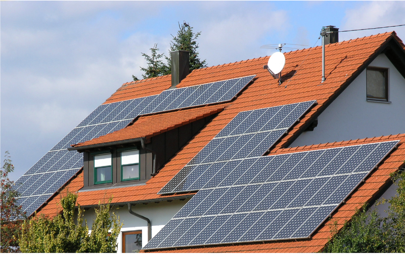 a house with a red roof and solar panels