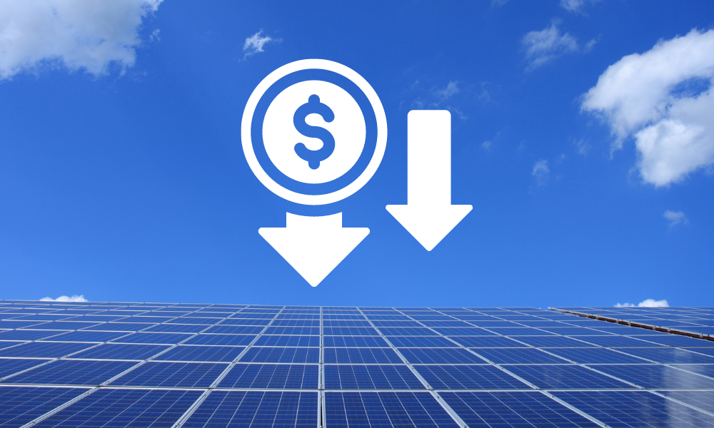 A field of solar panels under a bright blue sky with a few scattered clouds. Overlaid is a white icon of a dollar sign in a circle, accompanied by two downward arrows, suggesting a reduction in cost or expense.