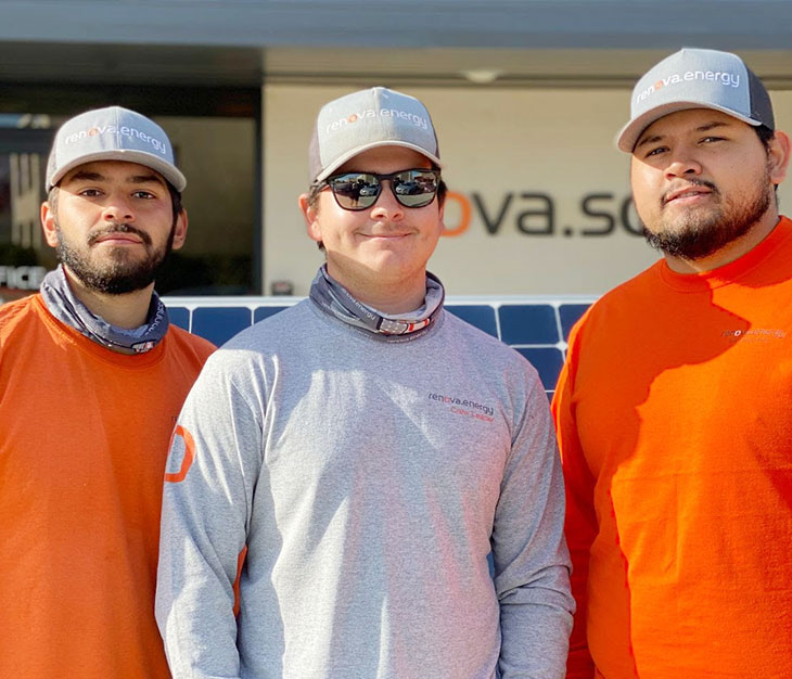 Three people stand outside wearing matching gray hats with renova.energy logos. Two wear orange shirts, and one wears a gray shirt and sunglasses. They smile at the camera, standing in front of a building with partial nova.s sign visible. Sunlight casts soft shadows.