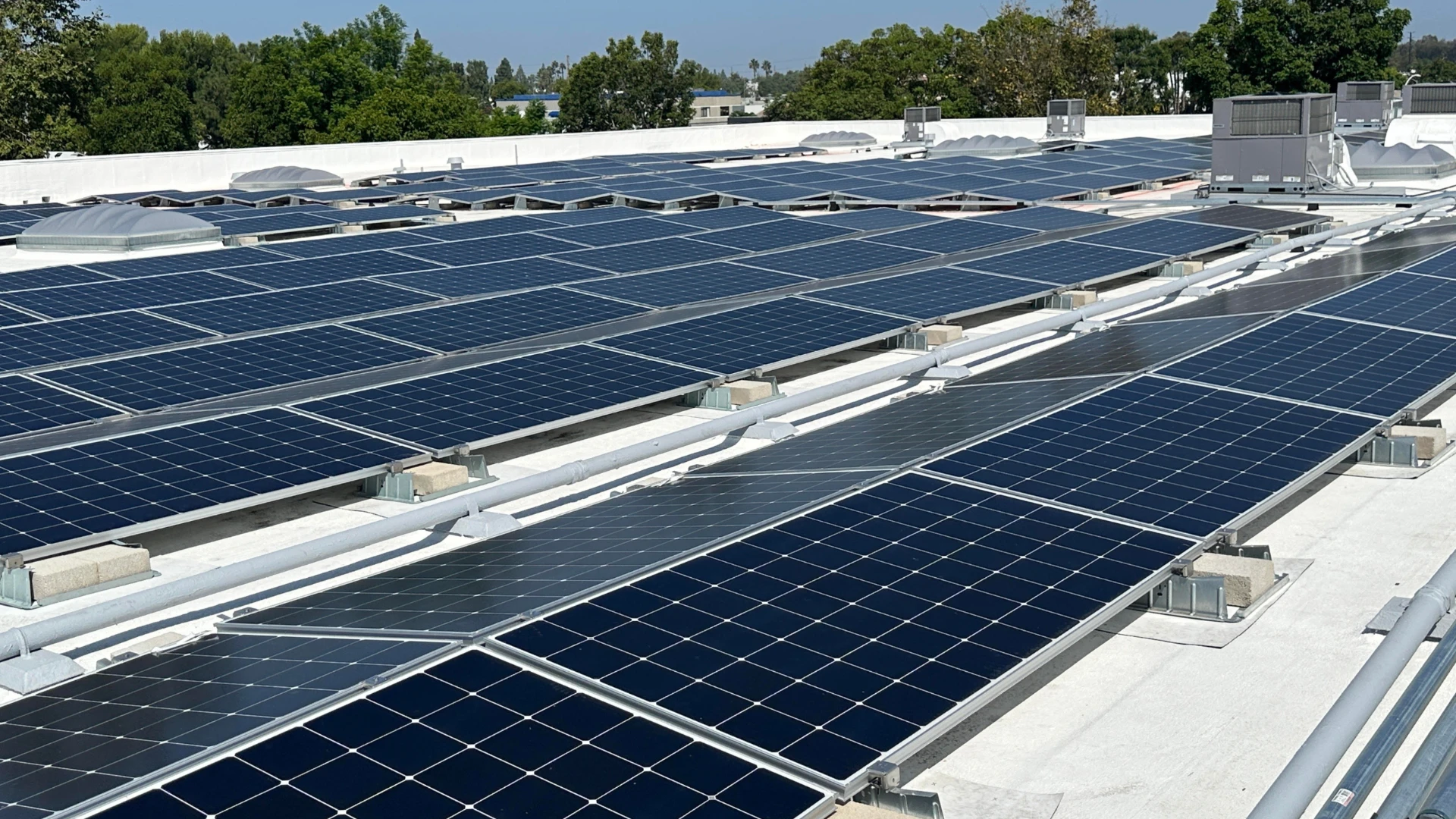 many solar panels aligned in a row on a roof of a building